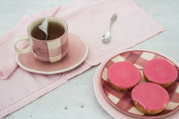 cake with pink frosting, called Roze Koek, typical treat in The Netherlands,  With cup of tad