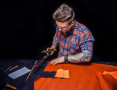 Craftsman working with leather working with leatherwork in leather studio