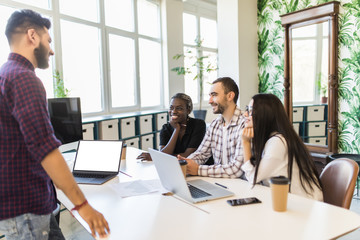 Relaxed informal IT business startup company meeting. Team leader discussing and brainstorming new approaches and ideas with colleagues. Startup business and entrepreneurship concept.