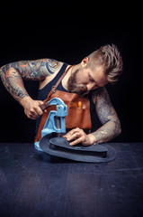 Professional Leather Worker being keen on his buisness in the tanner shop