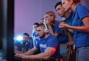 Young people playing video games on computers indoors. Esports tournament © New Africa