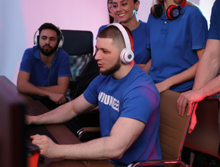 Young people playing video games on computers indoors. Esports tournament