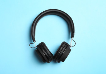 Stylish headphones on color background, top view