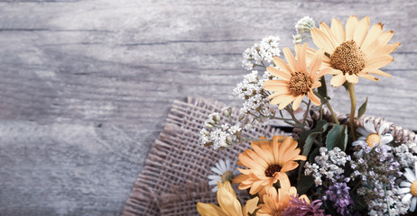 Wild flowers on old grunge wooden background (chamomile lupine dandelions thyme mint bells rape)