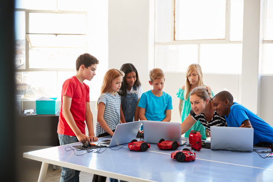 Group Of Students In After School Computer Coding Class Learning To Program Robot Vehicle