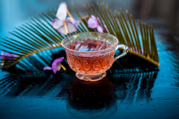 Detoxifying floral beneficial tea of rosemary in a transparent glass cup along with its flowers and...