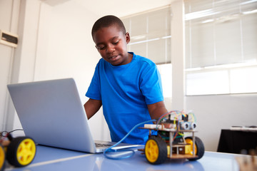 Male Student Building And Programing Robot Vehicle In After School Computer Coding Class