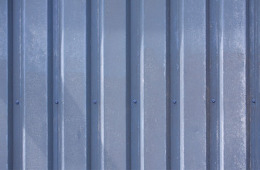 Close up photo of a facade from an industrial building with graphic stripes of minimalistic vertical blue weathered metal profiles. Background image.