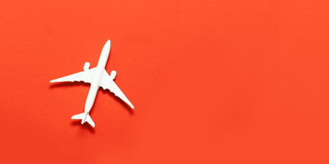 Travel concept. Airplane model, airplane on a bright red background.