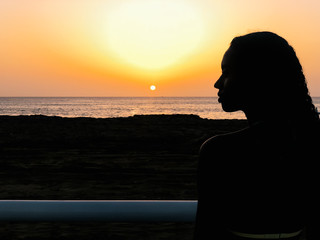 Black woman looking away the sunset on beach