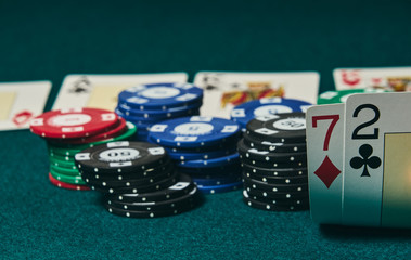 Bad poker gamble or unlucky hand concept with player going all in with 2 and 7 (two and seven) offsuit also called unsuited, considered the worst hand in poker preflop (before the flop is revealed)
