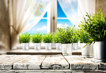 Wooden table of free space for your decoration. Small plant and summer window with sea landscape and beach. 