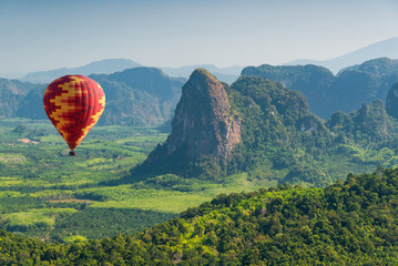 Air balloon flying over green mountains