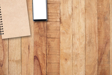Notepad and mobile phone on wooden table, copy space