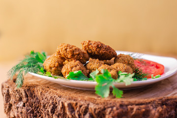 Falafel Closeup on Old Wooden Log, with Green Parsley and Tomato
