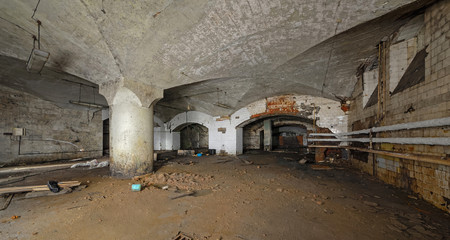 Fototapeta na wymiar AInterior of an abandoned underground wine cellar and warehouse of the 19th century. Wide support column