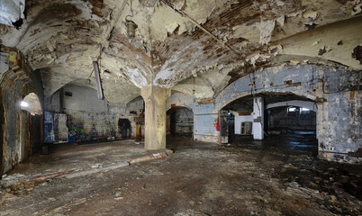 Fototapeta na wymiar Interior of an abandoned underground wine cellar and warehouse of the 19th century. Peeling paint