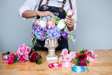 Arranging artificial flowers vest decoration at home, Young woman florist work making organizing diy artificial flower, craft and hand made concept