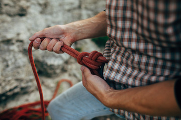 Male rock climber prepares to climb the cliff