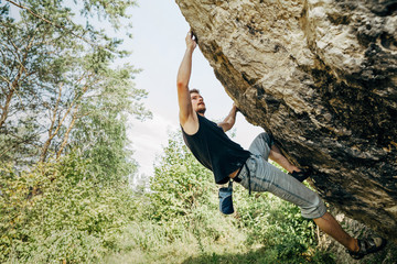 Male rock climber hanging on the cliff