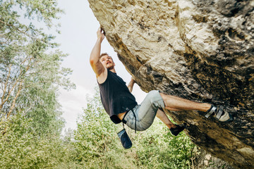 Male rock climber hanging on the cliff