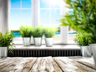 White wooden table of free space and white blurred window background of summer time 