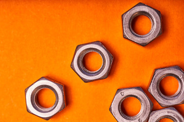 hex nuts on orange background. Bolted connection elements