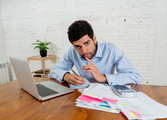 Stressed young man paying bills trying to manage home and business finances