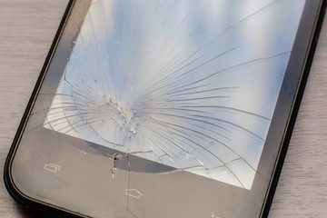 Part of the broken phone screen. Cracks on smartphone glass