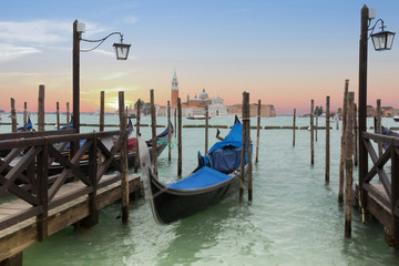 Fototapeta na wymiar Venetian gondolas in canal in evening time