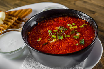 Beetroot soup Traditional Ukrainian or Russian borscht with sour cream in a bowl on wooden table