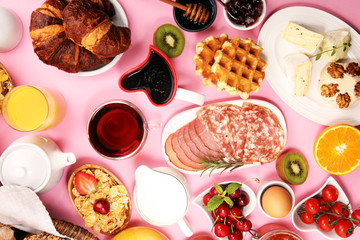 Huge healthy breakfast on table with coffee, orange juice, fruits, waffles and croissants. Good morning concept.