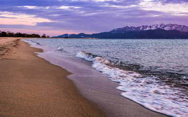 Empty beach in the evening - waves crashing on the sand