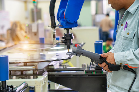 Professional engineers control the remote, move the robot arm to the mirror on the base.