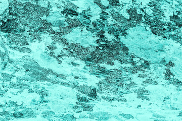 Vintage azure background. Rough painted wall of turquoise color. Imperfect plane of cyan colored. Uneven old decorative toned backdrop of aqzure tint. Texture of teal hue. Ornamental stony surface.
