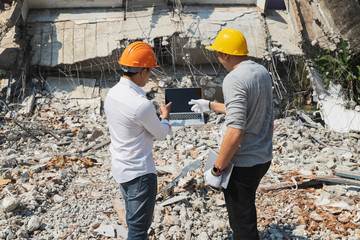 Demolition control supervisor and contractor discussing on demolish building.