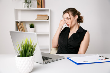 Tired and sick businesswoman at her desk in office