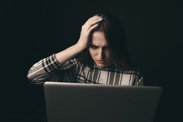 Teen girl excessively sitting at the computer laptop at home. he is a victim of online bullying Stalker social networks