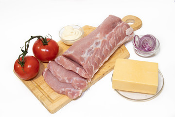 Pork chop isolated on white background. Meat on a white background. Raw meat and red tomatoes. Tomatoes on the branch.