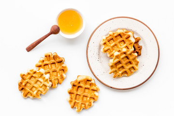 homemade Belgian waffles with honey on served table on white background top view