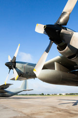 Military transport aircraft on runway at an airport.