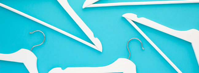 White wooden hangers on blue background