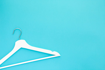 White wooden hangers on blue background