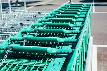 Line of green shopping carts in a supermarket