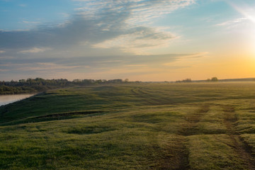 Fototapeta na wymiar Dawn in a field near the river