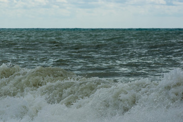 sea landscape is a pebbly beach with waves in white foam