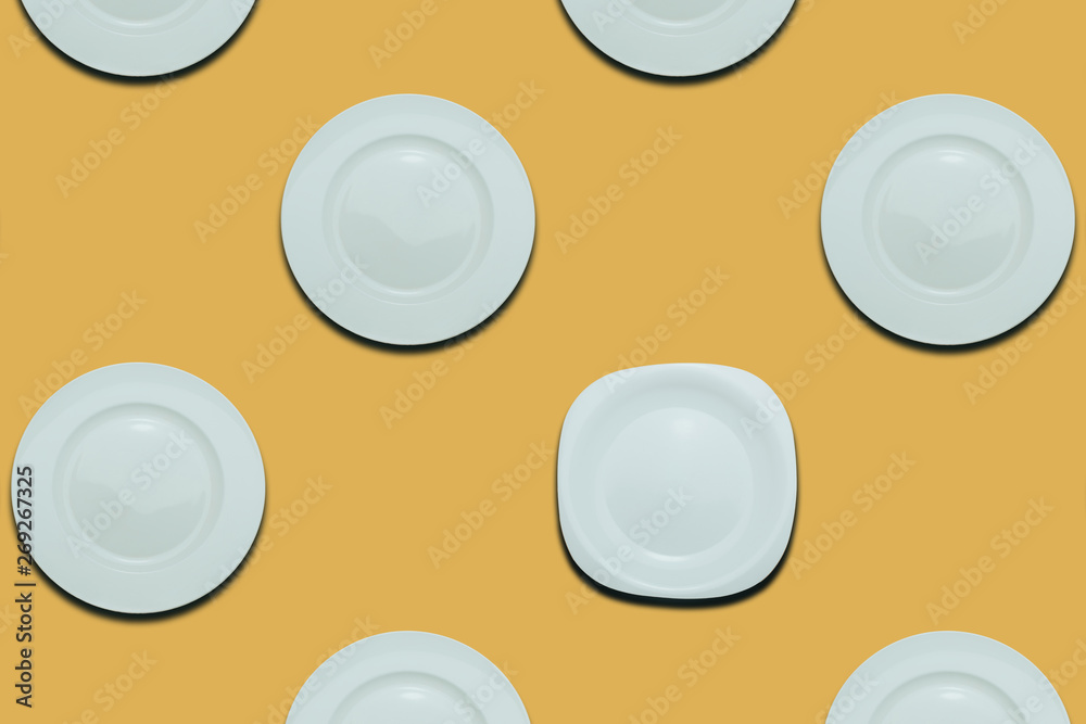 Poster white round plates and one different plate on a yellow flat background. copy space