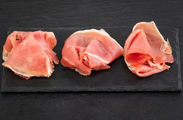 Italian prosciutto crudo or spanish jamon and sausages. Raw ham on stone cutting board, copy space,...
