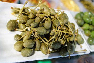 White plate with pickled green capers