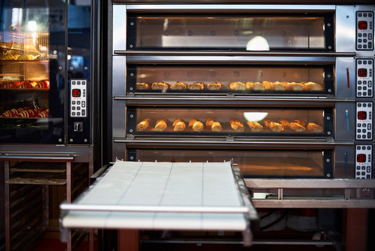 Industrial convection oven with cooked bakery products for catering. Professional kitchen equipment